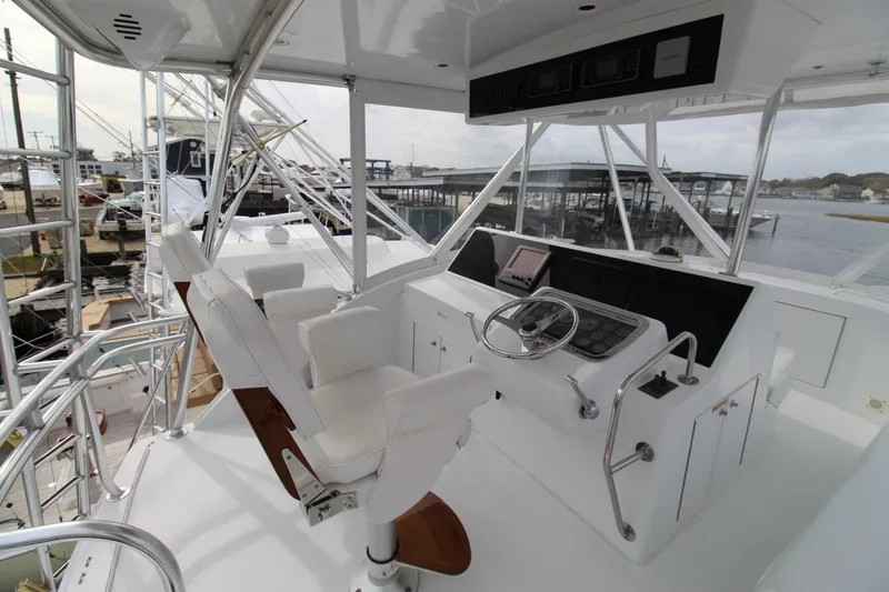 Slide: The Image of Helm of 2005 Hatteras 50' Convertible yacht with dual seats and navigation controls. - 38