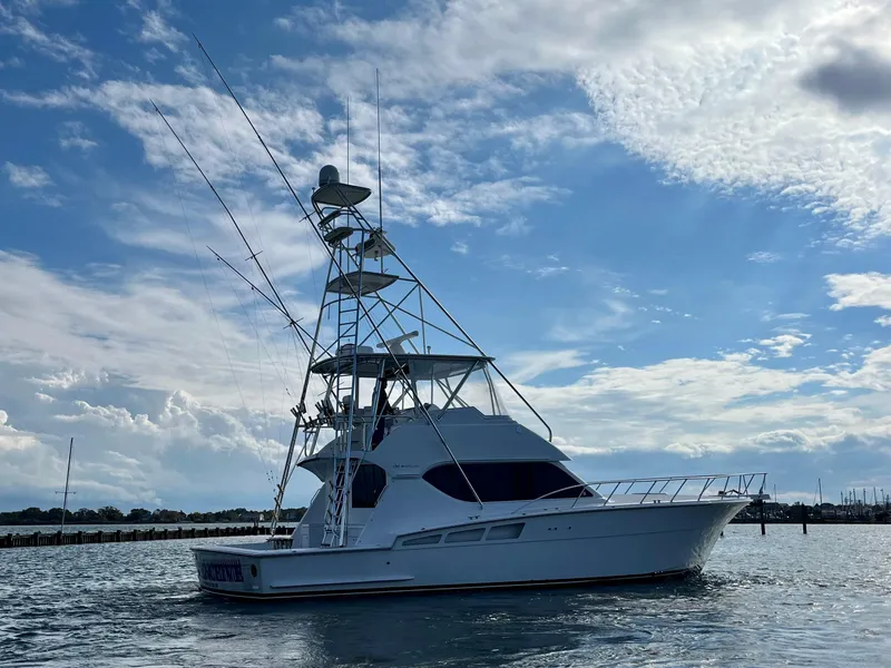 Slide: The Image of 2005 Hatteras 50' Convertible yacht on water under a partly cloudy sky. - 4