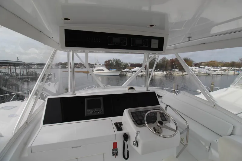 Slide: The Image of Helm of 2005 Hatteras 50' Convertible yacht with marina view. - 44