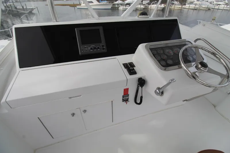 Slide: The Image of Helm of 2005 Hatteras 50' Convertible yacht with steering wheel and control panel. - 45