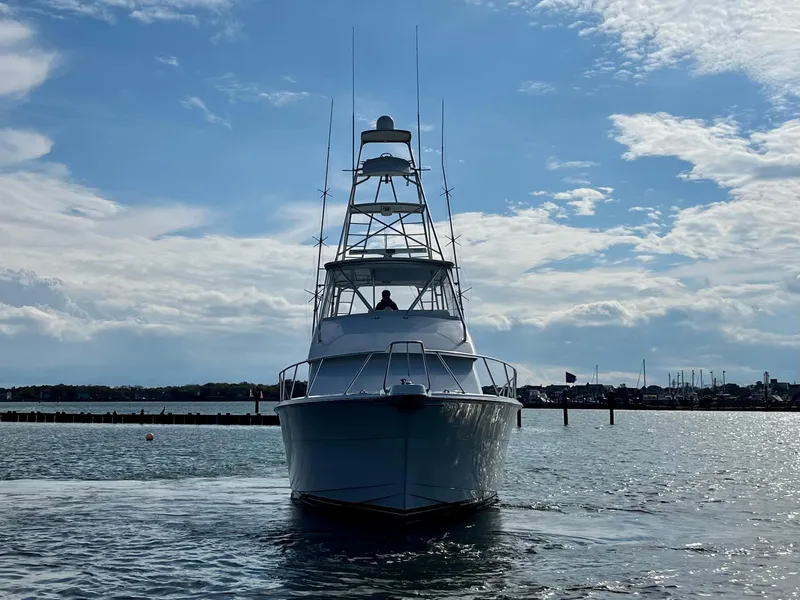 Slide: The Image of 2005 Hatteras 50' Convertible yacht on calm water under a partly cloudy sky. - 5