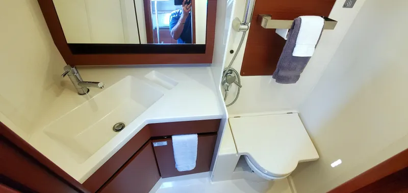Slide: The Image of Das Bild zeigt ein modernes Badezimmer auf einem Boot mit Waschbecken, Spiegel und Toilette. - 23