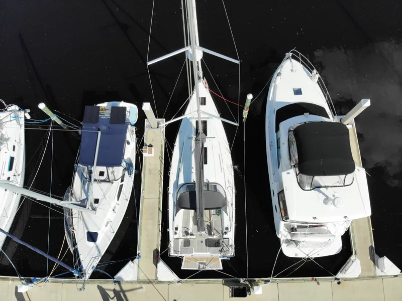 Slide: The Image of Drei Boote liegen nebeneinander an einem Dock. Das mittlere Boot ist ein Hanse 388 aus dem Jahr 2024. - 36