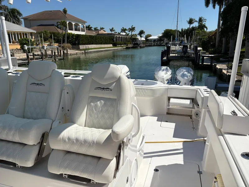 Slide: The Image of Invincible 40 Catamaran 2020 with luxurious seating, docked in a scenic canal setting. - 12