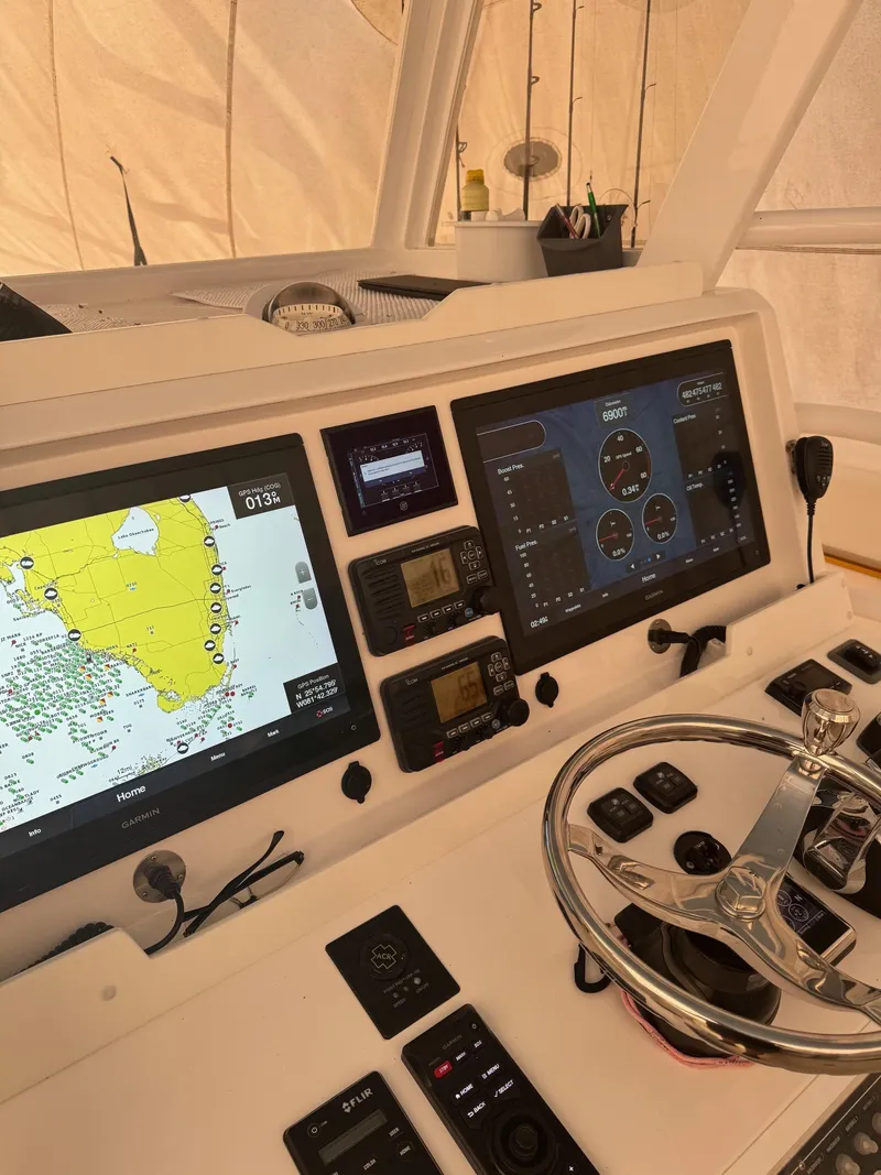 Slide: The Image of Control panel of a 2020 Invincible 40 Catamaran with navigation screens and steering wheel. - 14