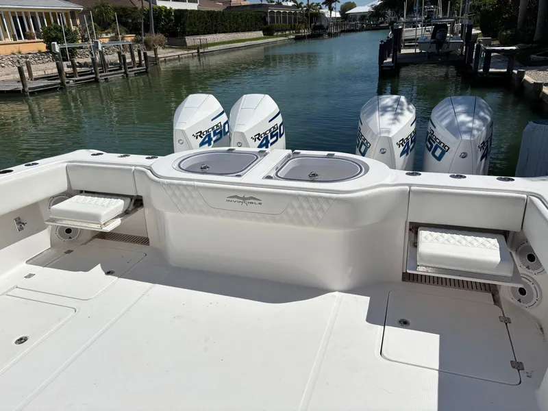 Slide: The Image of 2020 Invincible 40 Catamaran with quad engines docked in a serene canal setting. - 6