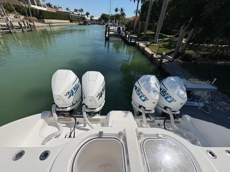 Slide: The Image of 2020 Invincible 40 Catamaran with quad outboard engines docked in a scenic canal. - 7
