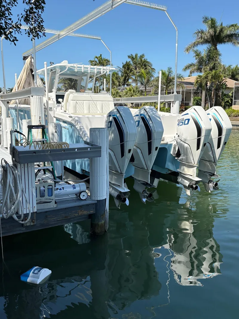 Slide: The Image of 2020 Invincible 40 Catamaran docked with powerful outboard engines, surrounded by tropical scenery. - 8