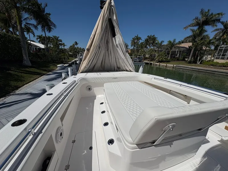 Slide: The Image of 2020 Invincible 40 Catamaran with white seating, docked near palm trees and waterfront homes. - 9