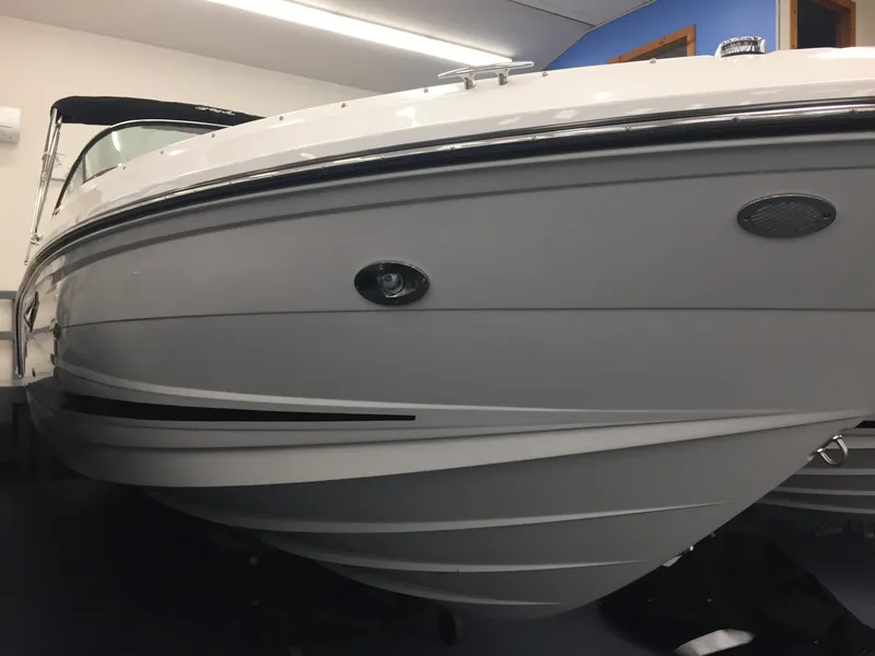 Slide: The Image of 2018 Sea Ray SLX 250 boat, sleek white hull, indoor showroom display. - 2