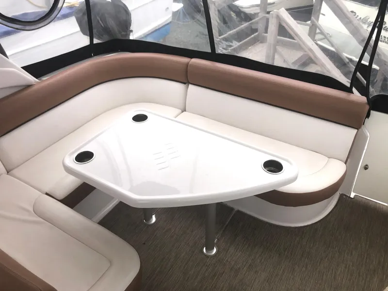 Slide: The Image of 2018 Four Winns V355 boat interior with brown and white seating and a triangular table. - 10
