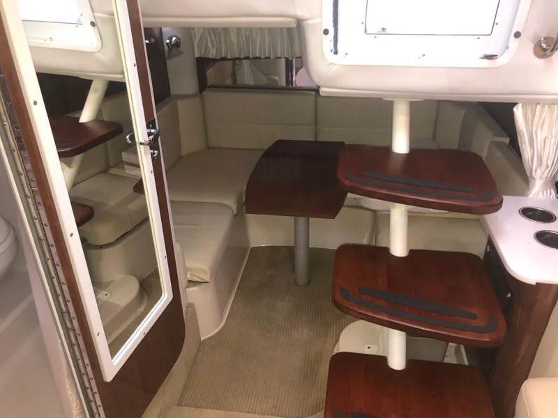 Slide: The Image of Interior of 2018 Four Winns V355 boat with seating and wooden tables. - 17