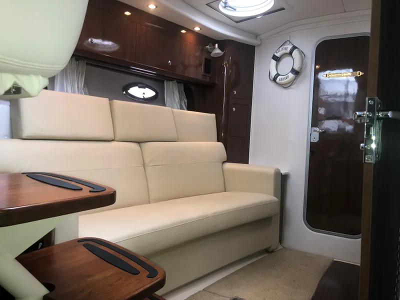 Slide: The Image of Interior of 2018 Four Winns V355 boat with beige seating and wooden accents. - 18
