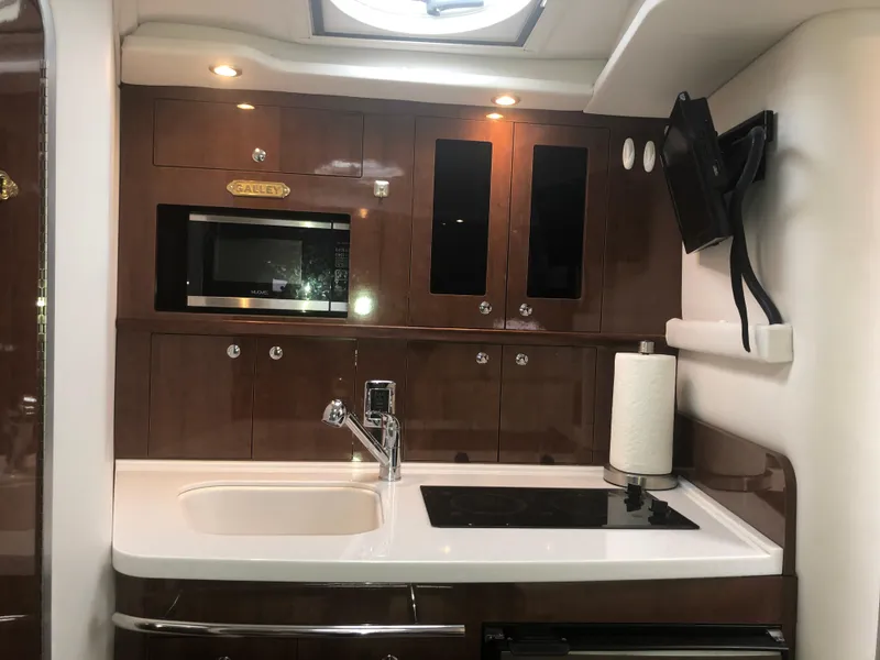 Slide: The Image of 2018 Four Winns V355 yacht kitchen with modern appliances and sleek cabinetry. - 23