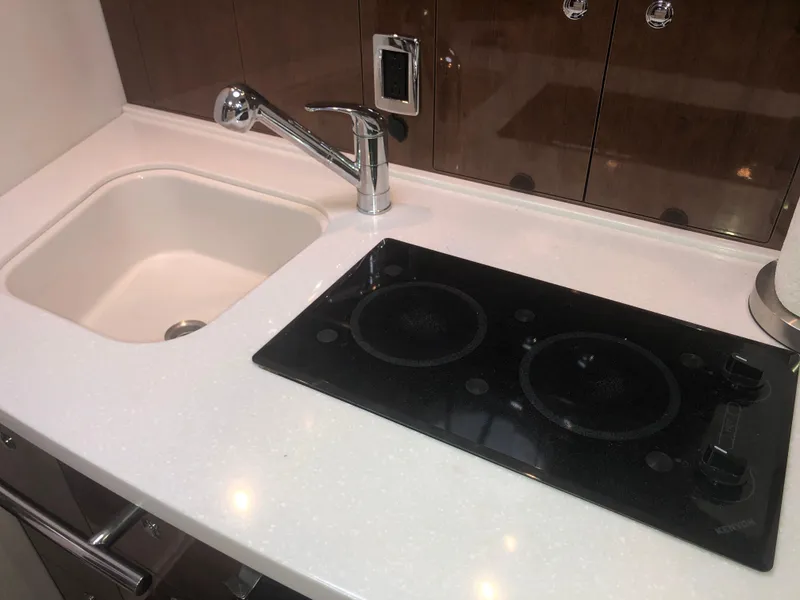 Slide: The Image of 2018 Four Winns V355 yacht kitchen with sink and stovetop. - 24