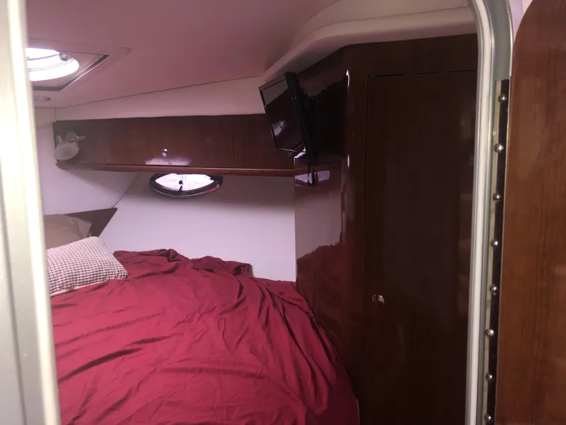 Slide: The Image of Interior cabin of 2018 Four Winns V355 boat with bed, TV, and wooden cabinetry. - 28