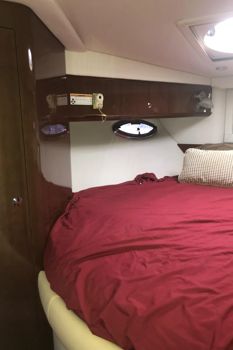 Slide: The Image of Interior cabin of 2018 Four Winns V355 with red bedding and wooden cabinetry. - 30
