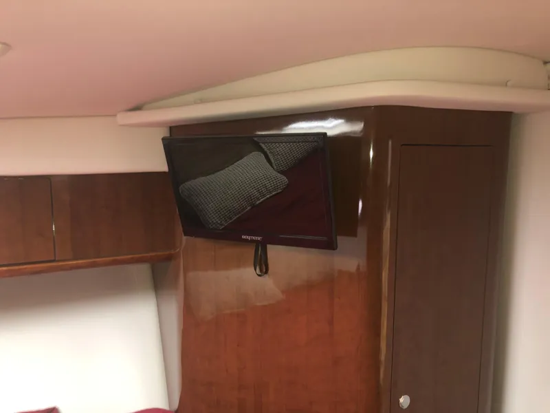 Slide: The Image of Interior of 2018 Four Winns V355 boat with mounted TV and wooden cabinetry. - 32