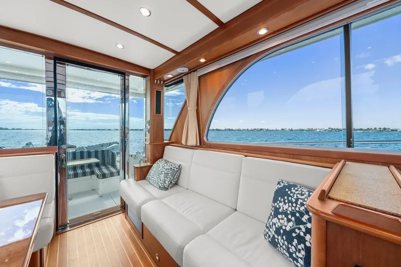 Slide: The Image of 2019 Sabre 45 Salon Express interior with ocean view, featuring elegant wood and white seating. - 8