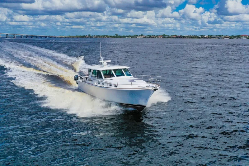 Slide: The Image of 2019 Sabre 45 Salon Express cruising on open water under a blue sky. - 94
