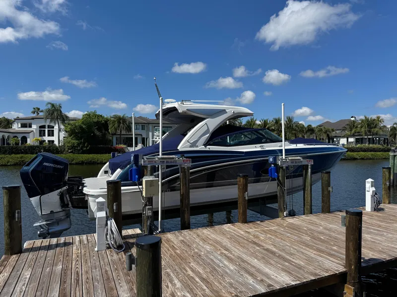 Slide: The Image of 2023 Formula 350 Crossover Bowrider docked by waterfront homes under blue sky. - 3