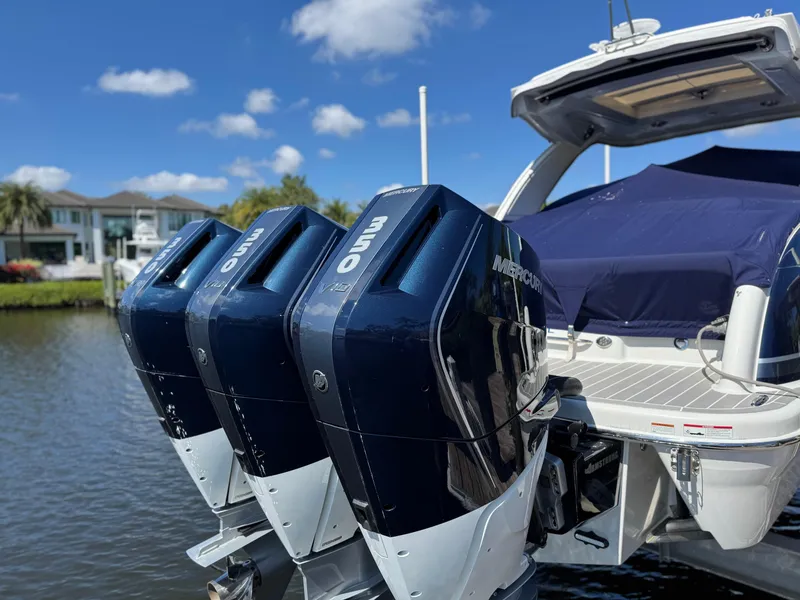 Slide: The Image of 2023 Formula 350 Crossover Bowrider with triple outboard engines docked by the water. - 5