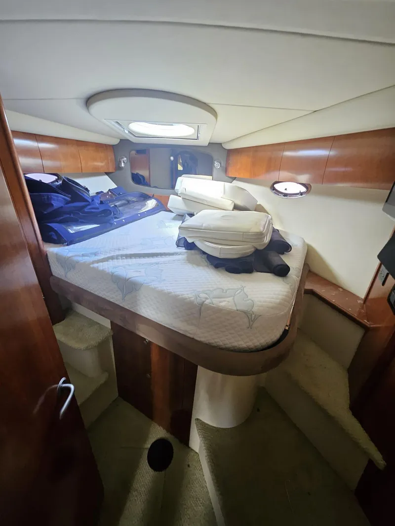 Slide: The Image of 2008 Cruisers Yachts 390 Sports Coupe cabin with bed, wooden accents, and porthole windows. - 8