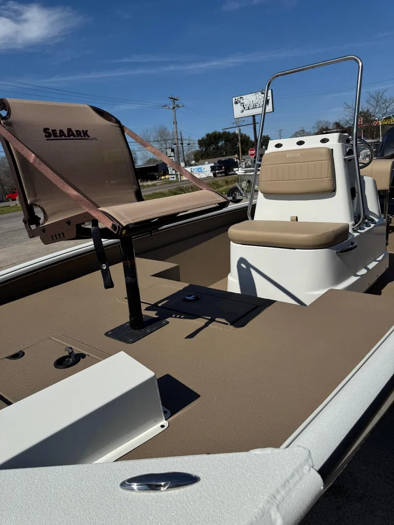 Slide: The Image of 2025 SeaArk Bay Runner 190 boat interior with seating and console under clear blue sky. - 10