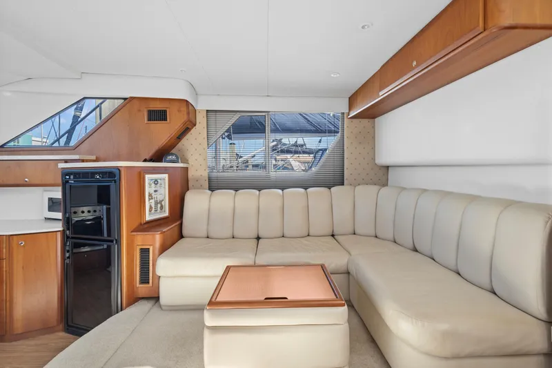 Slide: The Image of Interior of 2000 Silverton 392 Motor Yacht with beige seating and wooden accents. - 11