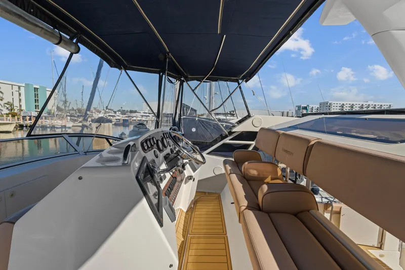 Slide: The Image of 2000 Silverton 392 Motor Yacht interior with helm, seating, and marina view. - 6