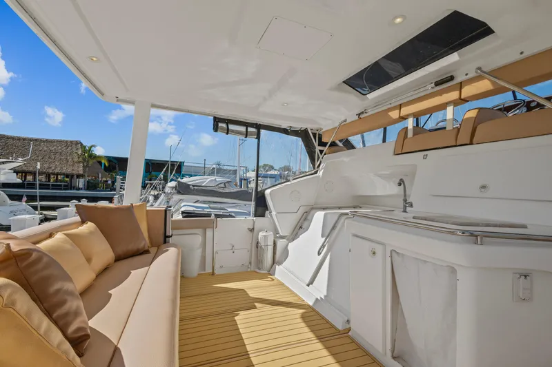 Slide: The Image of 2000 Silverton 392 Motor Yacht interior with seating and kitchenette, docked at marina. - 7