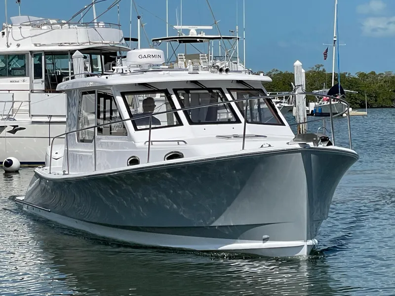 Slide: The Image of 2025 True North 34 Outboard Express boat docked in marina, clear sky background. - 1