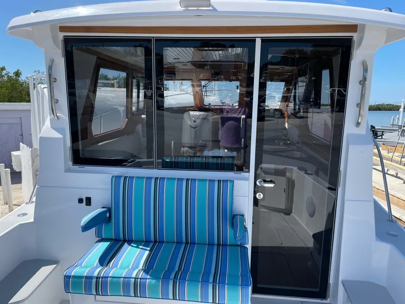 Slide: The Image of 2025 True North 34 Outboard Express boat with striped seating and glass doors. - 14