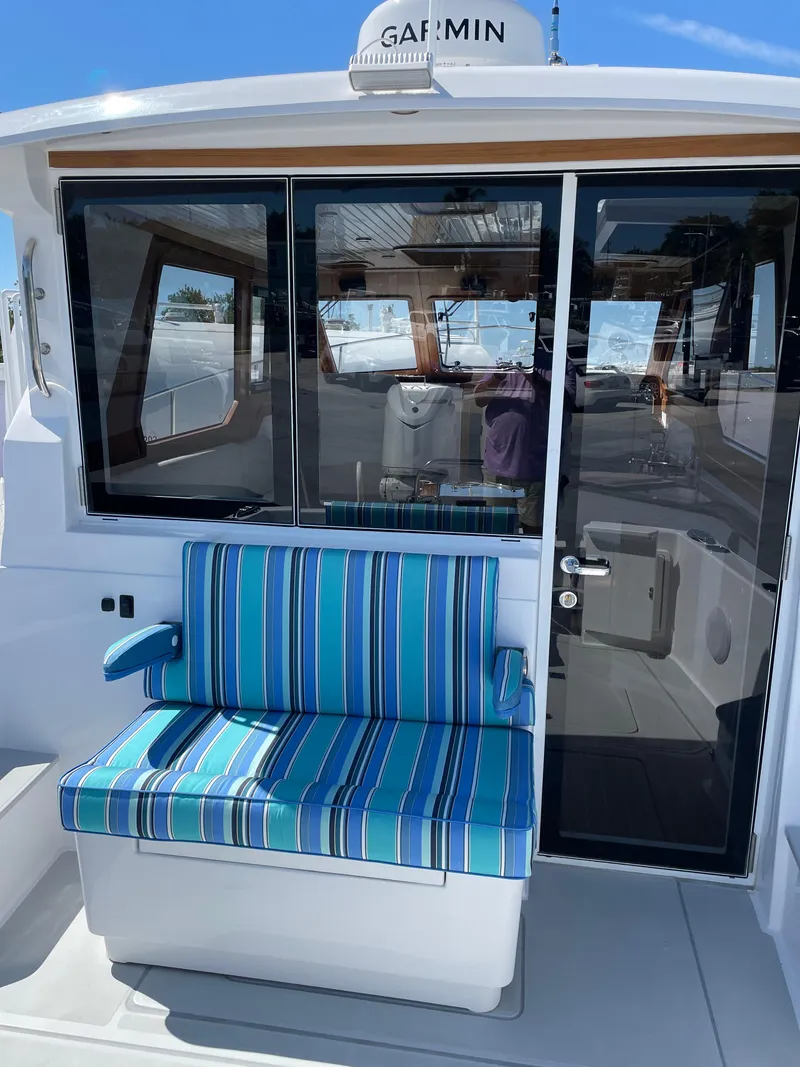 Slide: The Image of 2025 True North 34 Outboard Express boat with striped seating and glass door. - 16