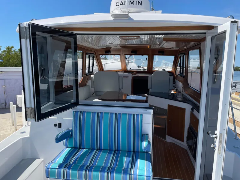 Slide: The Image of 2025 True North 34 Outboard Express boat interior with striped seating and open cabin. - 17