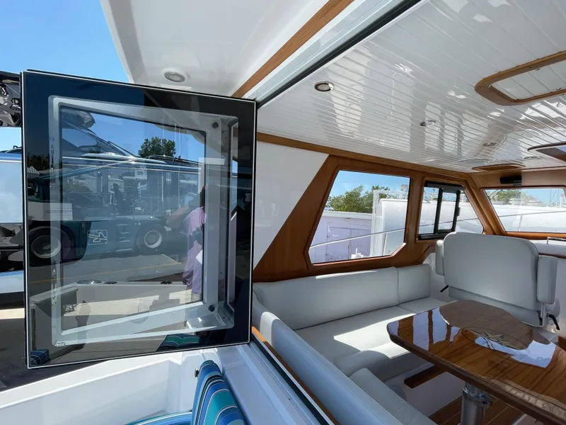 Slide: The Image of Interior of 2025 True North 34 Outboard Express yacht with modern seating and wood accents. - 19