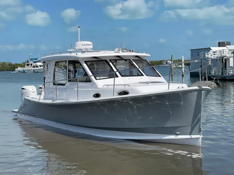 Slide: The Image of 2025 True North 34 Outboard Express boat docked on calm water under a blue sky. - 2