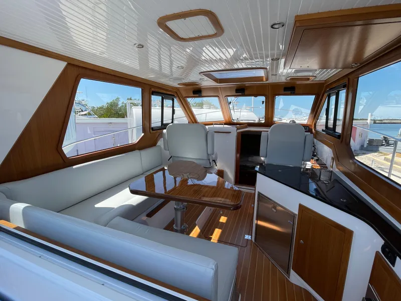 Slide: The Image of Interior of 2025 True North 34 Outboard Express, featuring elegant wood finishes and spacious seating. - 20