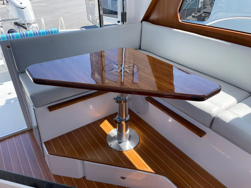 Slide: The Image of Luxurious interior of 2025 True North 34 Outboard Express with polished wood table. - 21