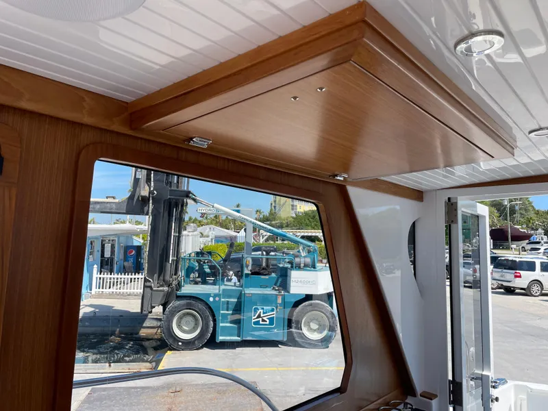Slide: The Image of Interior view of 2025 True North 34 Outboard Express with forklift visible outside window. - 24