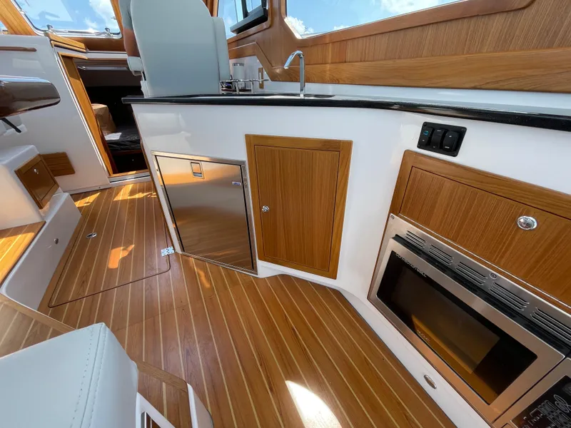 Slide: The Image of Interior of 2025 True North 34 Outboard Express with wood finish and modern appliances. - 25