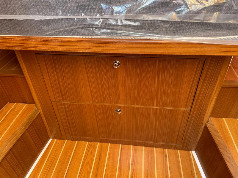 Slide: The Image of Wooden interior of 2025 True North 34 Outboard Express boat, featuring storage compartments. - 42