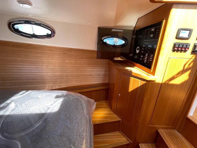 Slide: The Image of Interior of 2025 True North 34 Outboard Express, featuring wood paneling and control panel. - 45