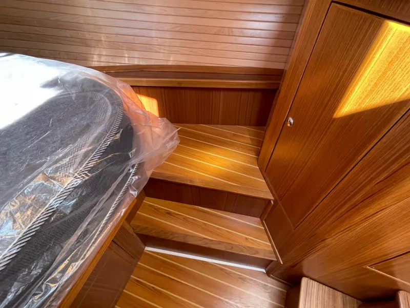 Slide: The Image of Interior of 2025 True North 34 Outboard Express, featuring wooden steps and cabinetry. - 46