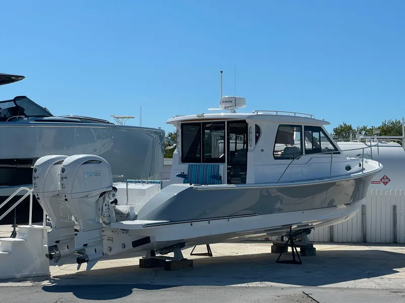 Slide: The Image of 2025 True North 34 Outboard Express boat on display in a marina setting. - 5