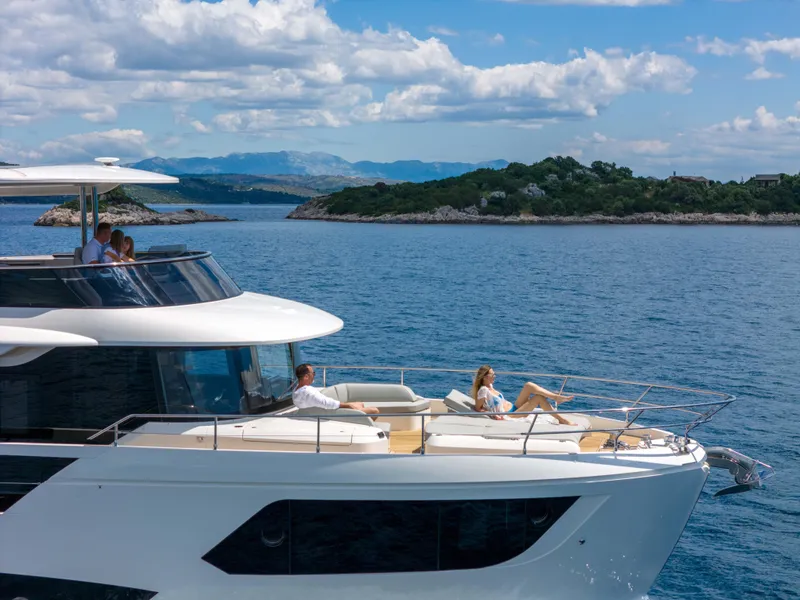 Slide: The Image of 2024 Absolute NAVETTA 75 yacht cruising near scenic coastline under blue skies. - 12