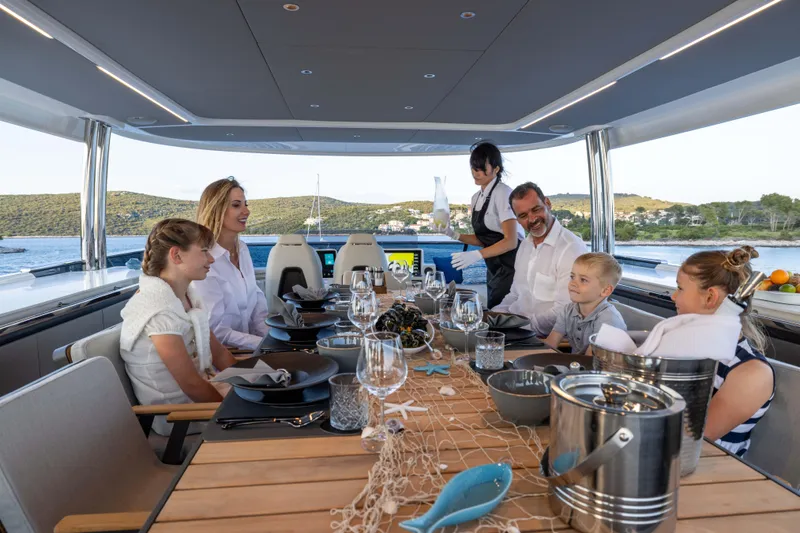 Slide: The Image of Family dining on Absolute NAVETTA 75 yacht, 2024 model, enjoying a meal with scenic views. - 34