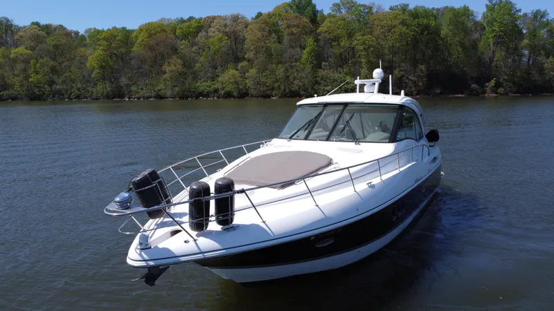 Slide: The Image of 2009 Cruisers Yachts 420 Sports Coupe on a serene lake with lush green trees. - 10