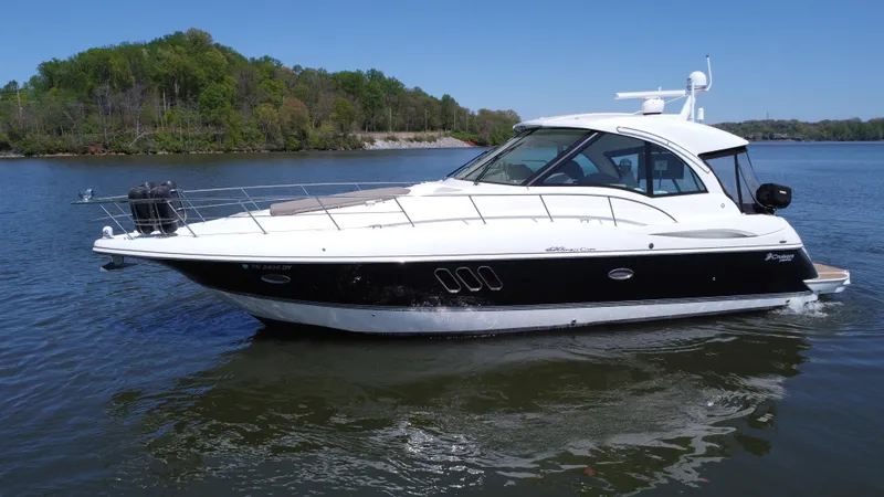 Slide: The Image of 2009 Cruisers Yachts 420 Sports Coupe on calm water, surrounded by lush greenery. - 11