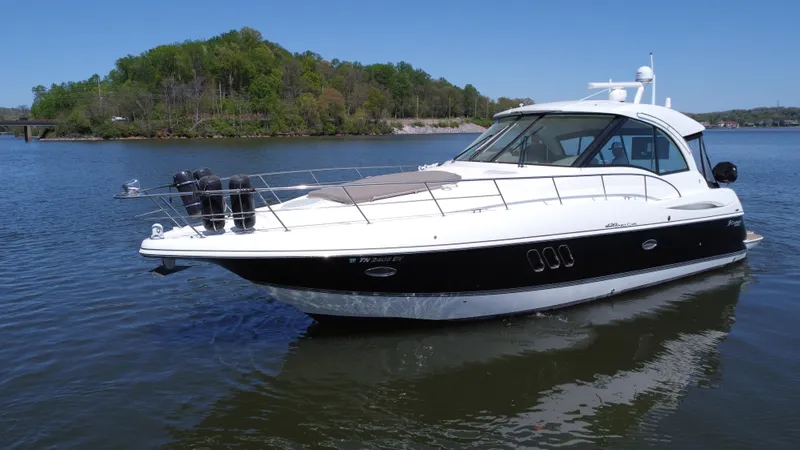 Slide: The Image of 2009 Cruisers Yachts 420 Sports Coupe on calm water, with lush green shoreline. - 18